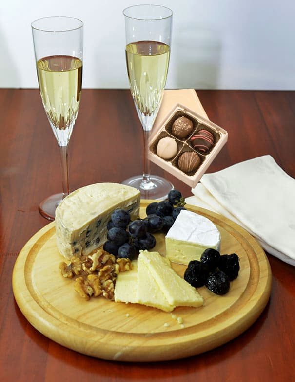 Cheese board with fruit, crackers, and sparkling wine for a romantic evening